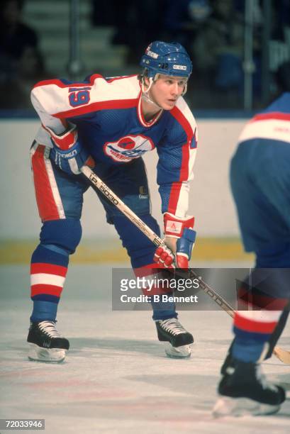American professional hockey player Brian Mullen, forward for the Winnipeg Jets, leans over readied on the ice during a game with the New York...