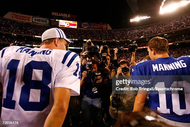 Peyton Manning of the Indianapolis Colts meets with brother Eli Manning of the New York Giants in the middle of the field on September 10, 2006 at...