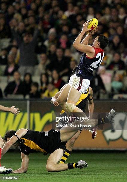 Russell Robertson of the Demons takes a high mark over Joel Bowden of the Tigers during the round 15 AFL match between the Richmond Tigers and the...