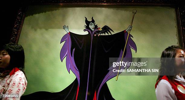 Staff stand next to a portrait of Disney character Cruella De Vil during a Halloween celebration press preview in Hong Kong, 29 September 2006. The...