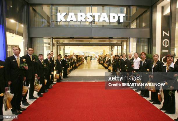 Employees of a newly-opened outlet of German retail giant Karstadt line up as they wait for customers in Leipzig 29 September 2006. German retail...