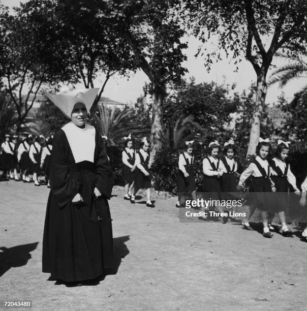 Nun takes the girls from a parochial school in Sicily for a walk, circa 1955.