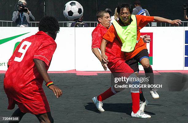 Cape Town, SOUTH AFRICA: Austria's Peter Mitsche , clashes with Hong Kong's Vegas Yarf , as Austria's Effah Opokuh, also chases the ball, during...
