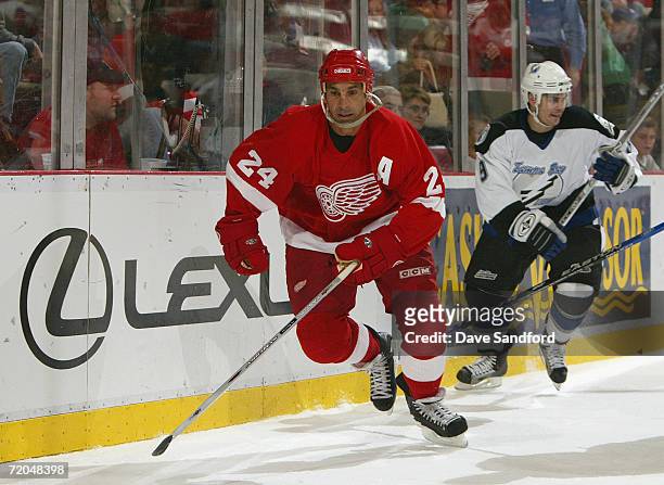 Chris Chelios of the Detroit Red Wings skates from the end boards away from Eric Perrin of the Tampa Bay Lightning during their NHL pre-season game...