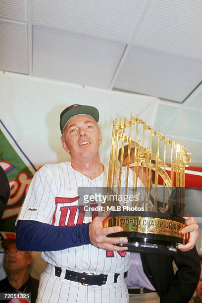 Manager Tom Kelly of the Minnesota Twins holds the World Series trophy in the locker room after defeating the St. Louis Cardinals 4-2 in game seven...