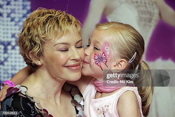 Singer Kylie Minogue is kissed by her fan, Megan Hondius , during a signing of her new book "The Showgirl Princess" at Waterstone's Oxford Street on...