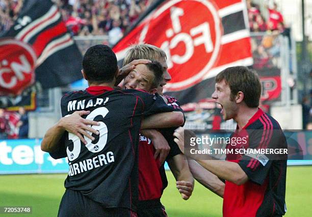 Nuremberg's Czech midfielder Jan Polak celebrates with teamates, Tunisian midfielder Jawhar Mnari and Russian striker Ivan Saenko , after scoring...