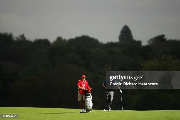 Tiger Woods of USA waits to hit his approach shot on the 8th hole with caddy Steve Williams during the third round of the WGC American Express...