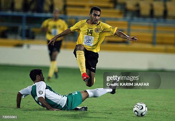 Mohammed Yasser Mohammedi of Qatar club jumps on al-Ahli player Yunes Ali during their Qatari championship football match in Doha, 30 September 2006....