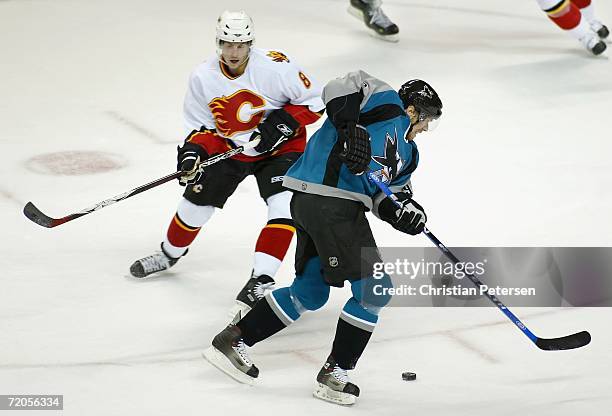 Milan Michalek of the San Jose Sharks skates past Brad Ference of the Calgary Flames on his way to score a goal during the first period of the...