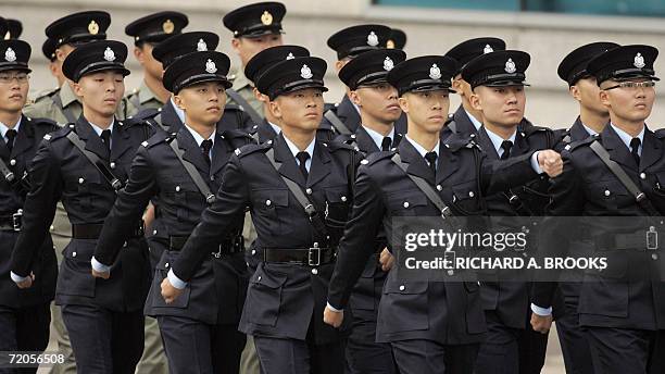 Members of the Hong Kong police march in formation ahead of an official flag raising ceremony outside the Hong Kong Convention and Exhibition Centre,...