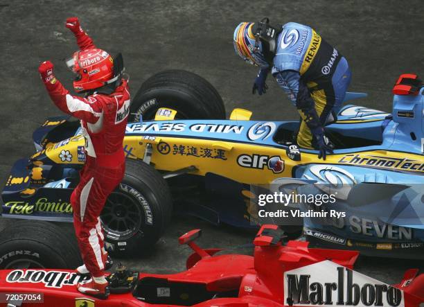 Michael Schumacher of Germany and Ferrari, finishing 1st, celebrates as Fernando Alonso of Spain and Renault, finishing 2nd, steps out of his car...