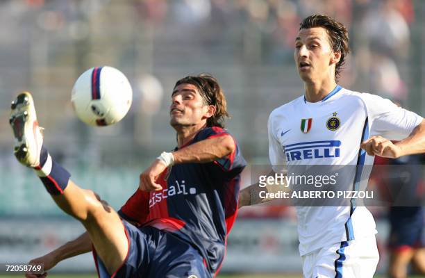 Inter Milan Zlatan Ibrahimovic of Sweden fights for the ball with Cagliari forward Mauro Esposito during their Italian Serie A football match at...