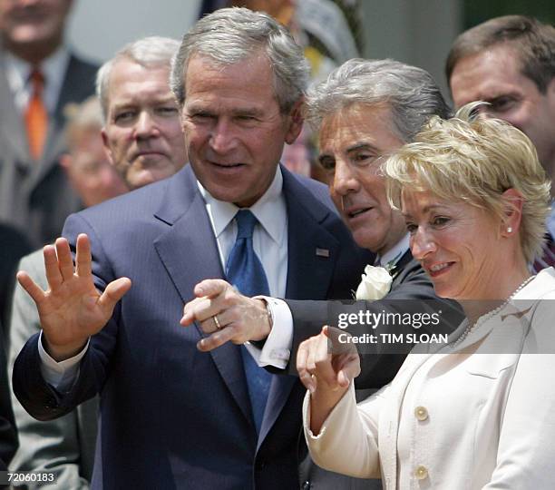 Washington, UNITED STATES: President George W. Bush talks with John Walsh and Walsh's wife Reve before the Signing of H.R. 4472, the Adam Walsh Child...