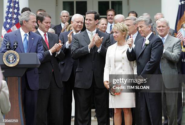 Washington, UNITED STATES: US President George W. Bush receives a thumbs up from John Walsh and his wife Reve before Signing of H.R. 4472, the Adam...