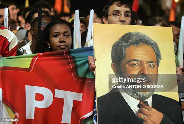 Supporters of the Brazilian President Luiz Inacio Lula da Silva holds a Workers' Party flag and a painting of Lula da Silva during a rally 01...