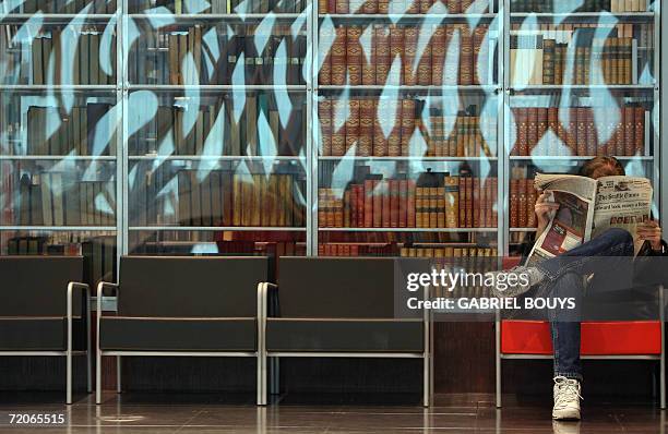 Seattle, UNITED STATES: A man reads a newspaper in the main hallat the new Seattle Public Library 30 September 2006 in Seattle, Washington. The...