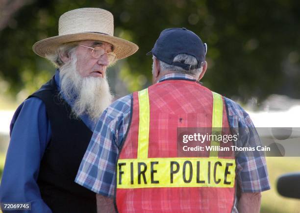 An Amish man speaks with a fire police officer at the scene of a shooting at a one room Amish schoolhouse October 2, 2006 in Nickel Mines,...