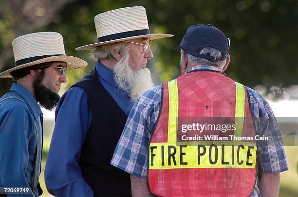 An Amish man speaks with a fire police officer at the scene of a shooting at a one room Amish schoolhouse October 2, 2006 in Nickel Mines,...