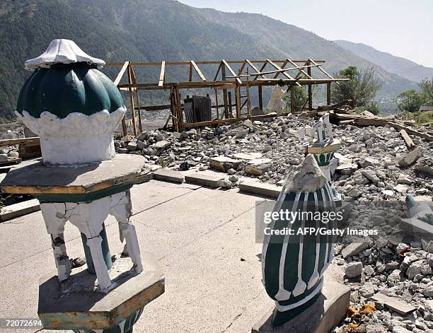 Pakistani man works on a wood shelter near a mosque which collapsed in the 08 October 2005 earthquake in Balakot, in the North West Frontier...