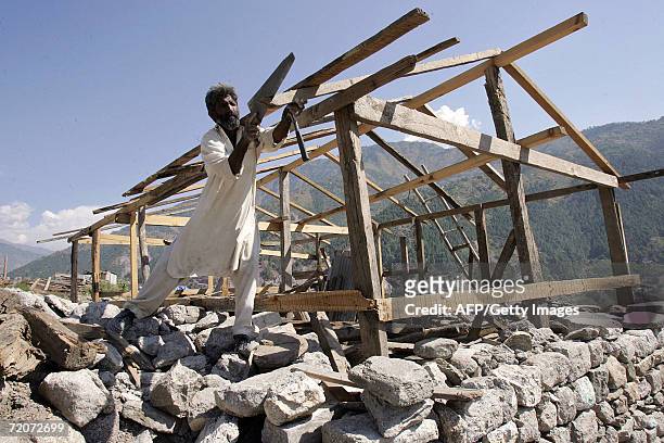 Pakistani man works on a wood shelter near a mosque which collapsed in the 08 October 2005 earthquake in Balakot, in the North West Frontier...