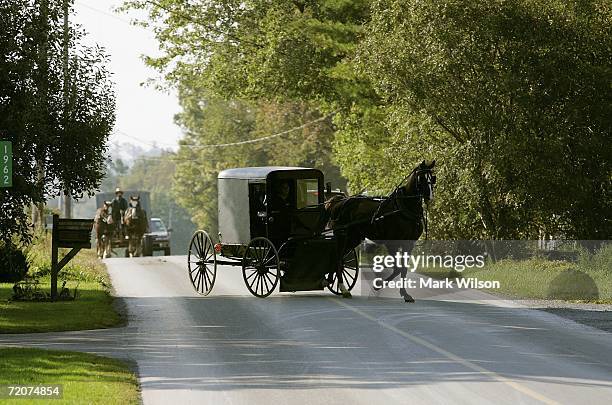 Horse drawn buggy arrives where members of the Amish community are gathering at the home of one of the girls that was killed yesterday at the one...