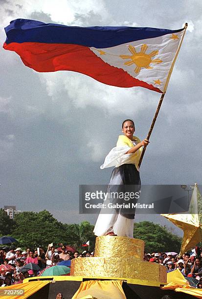 Filipino woman waves a national flag during the 104th independence day from Spain celebrations June 12, 2002 in Manila, Phillippines. President...