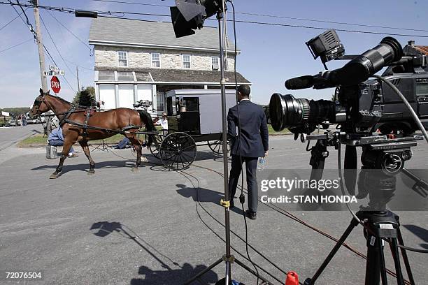 Nickel Mines, UNITED STATES: An Amish horse and buggy goes past a television camera near the one-room West Nickel Mines Amish School 03 October 2006...