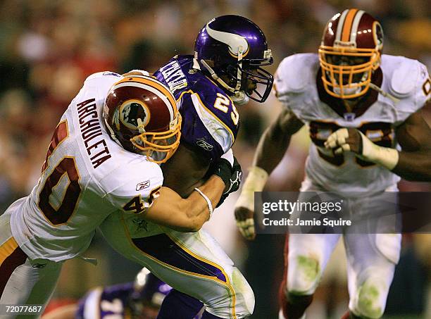 Chester Taylor of the Minnesota Vikings gets tackled by Adam Archuleta from the Washington Redskins on the first Monday Night Football game of the...