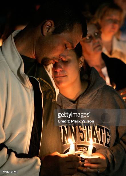 Chris Beiler hugs his wife Kristen Beiler during a candle light vigil for members of the Amish community, that were involved in the shooting that...