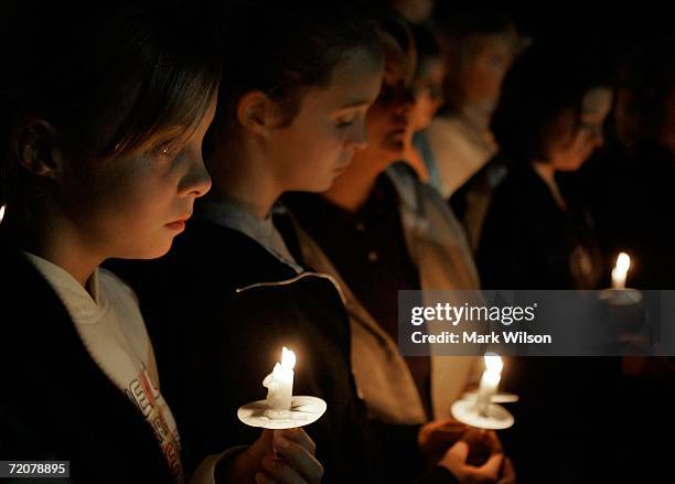 Young girls participate in a candle light vigil, for members of the Amish community that were involved in the shooting that took place in Nickel...