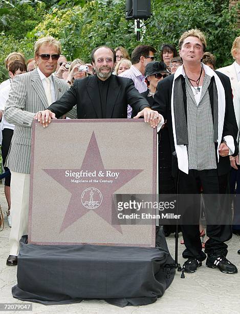 Siegfried Fischbacher and Roy Horn of the illusionist duo Siegfried & Roy, and their longtime manager Bernie Yuman pose with their star outside The...