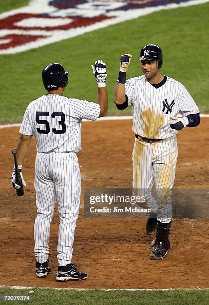 Shortstop Derek Jeter of the New York Yankees celebrates with Bobby Abreu after his home run tying the post season record for hits by going 5 for 5...