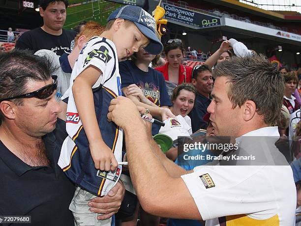 Shaun Berrigan of the Broncos signs a young fan's jersey as the Brisbane Broncos celebrate their NRL Grand Final win during a Grand Final parade...