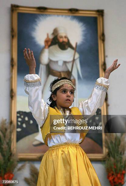 Iran-religion-minority-Zoroastrian An Iranian Zoroastrian girl performs a traditional dance in front of a painting of Iranian Prophet Zarathustra...