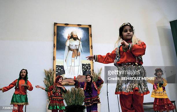Iran-religion-minority-Zoroastrian Iranian Zoroastrian girls perform a traditional dance in front of a painting of Iranian Prophet Zarathustra during...