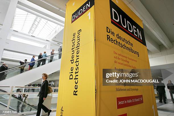 Fair-goers walk past an oversized Duden dictionary of "Correct German Spelling" at the international Frankfurt Book Fair 04 October 2006. The world's...