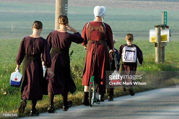 An Amish women escorts young children to school near the one room Amish schoolhouse where the shooting took place two days prior, October 4, 2006 in...