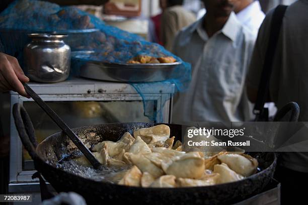 market vendor cooking samosa - mumbai market stock pictures, royalty-free photos & images