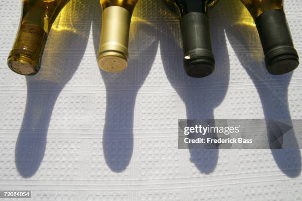 bottles of wine on table - white wine bottle tablecloth stock pictures, royalty-free photos & images
