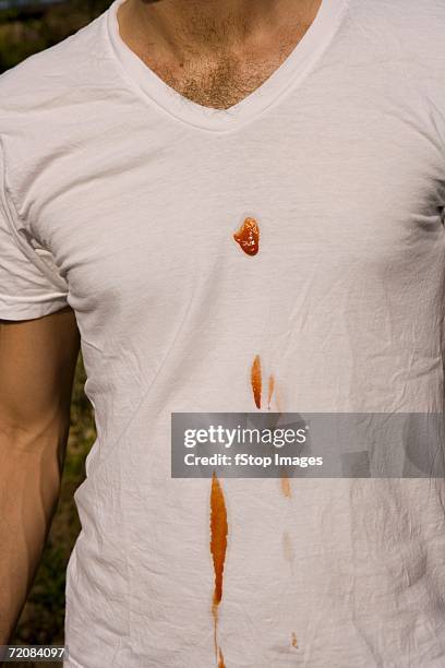 man with ketchup stain on t-shirt - food stain stock-fotos und bilder