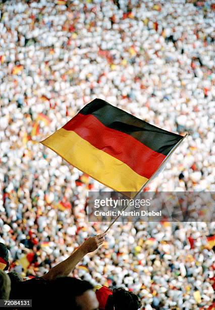 spectator holding german flag at sports event - germany soccer stock-fotos und bilder