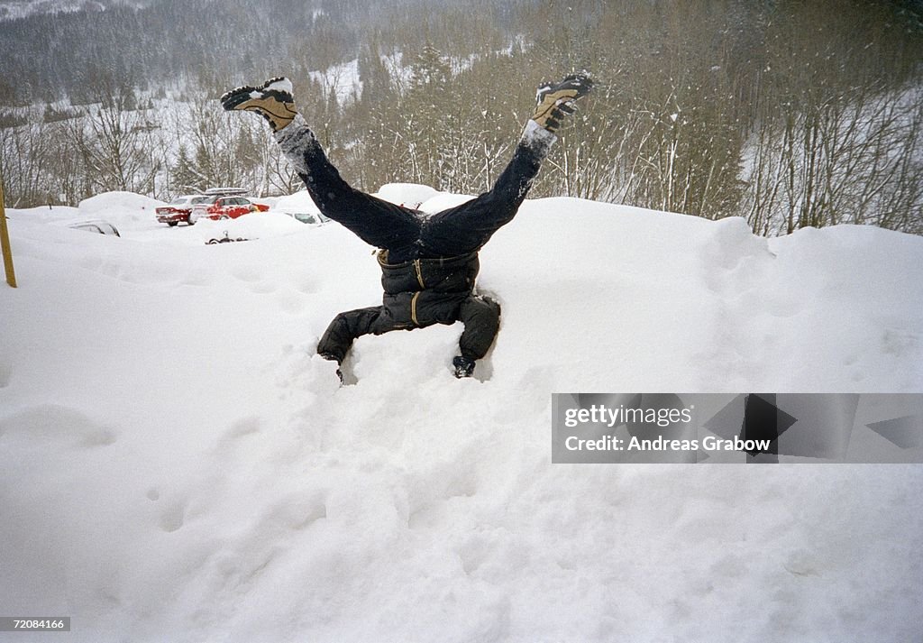 Man with head buried in pile of snow