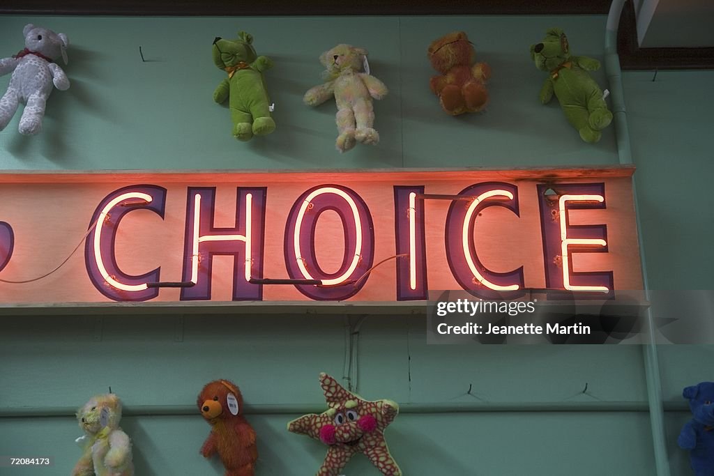 Teddy bears surrounding ?choice? neon sign