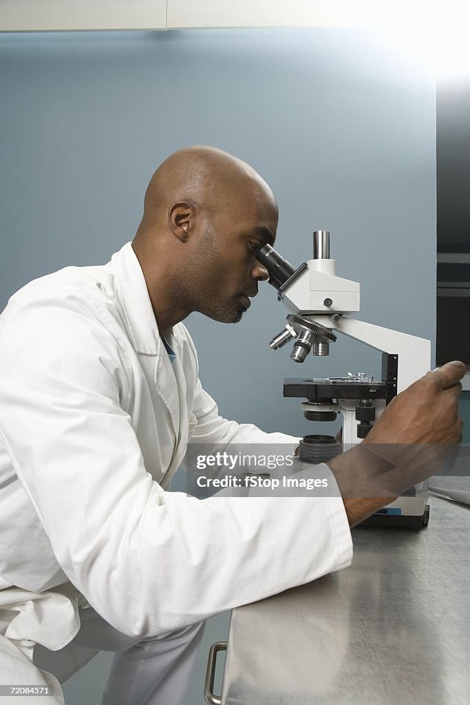 Technician looking into microscope