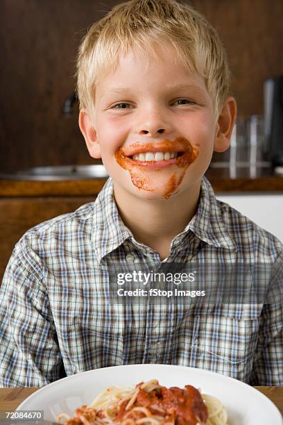 boy with food around mouth smiling - white shirt stain stock pictures, royalty-free photos & images