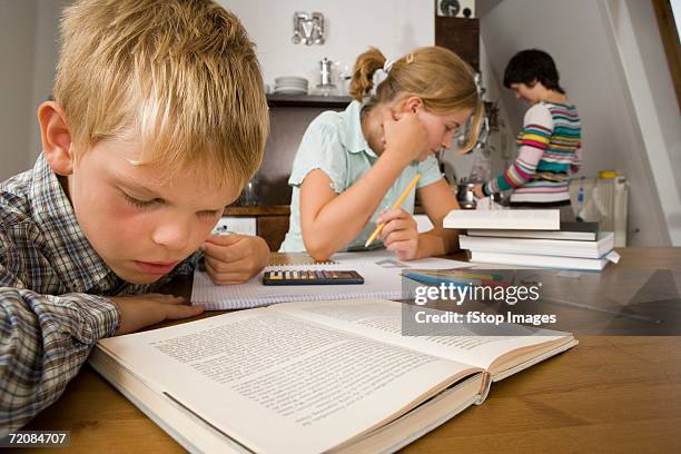 Two Make Homework Two Children Doing Homework With Mother High-Res Stock Photo - Getty Images