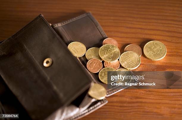 open wallet with coins spilling onto table - metallic purse imagens e fotografias de stock