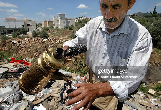 Palestinian vendor, Saud Turkeman sells Arabic coffee for $0.20 a cup along the rubble-strewn gully that officially divides the Israeli and...