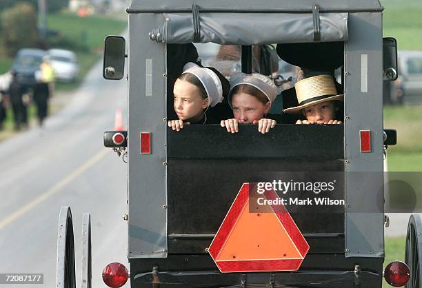 Amish children ride in the back of a buggy as they travel to a wake at the home of two of the Amish school shooting victims October 3, 2006 in Nickel...